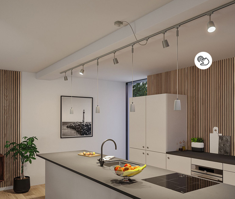 Bewegliche Spots an Lichtschiene über einer Kochinsel mit Spülbecken und viel Arbeitsfläche