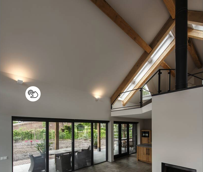 Hoher Raum mit Sichtdachstuhl und modernen Uplight-Wandleuchten unter der Dachschräge mit Balken Hoher Raum mit Sichtdachstuhl und modernen Uplight-Wandleuchten unter der Dachschräge mit Balken