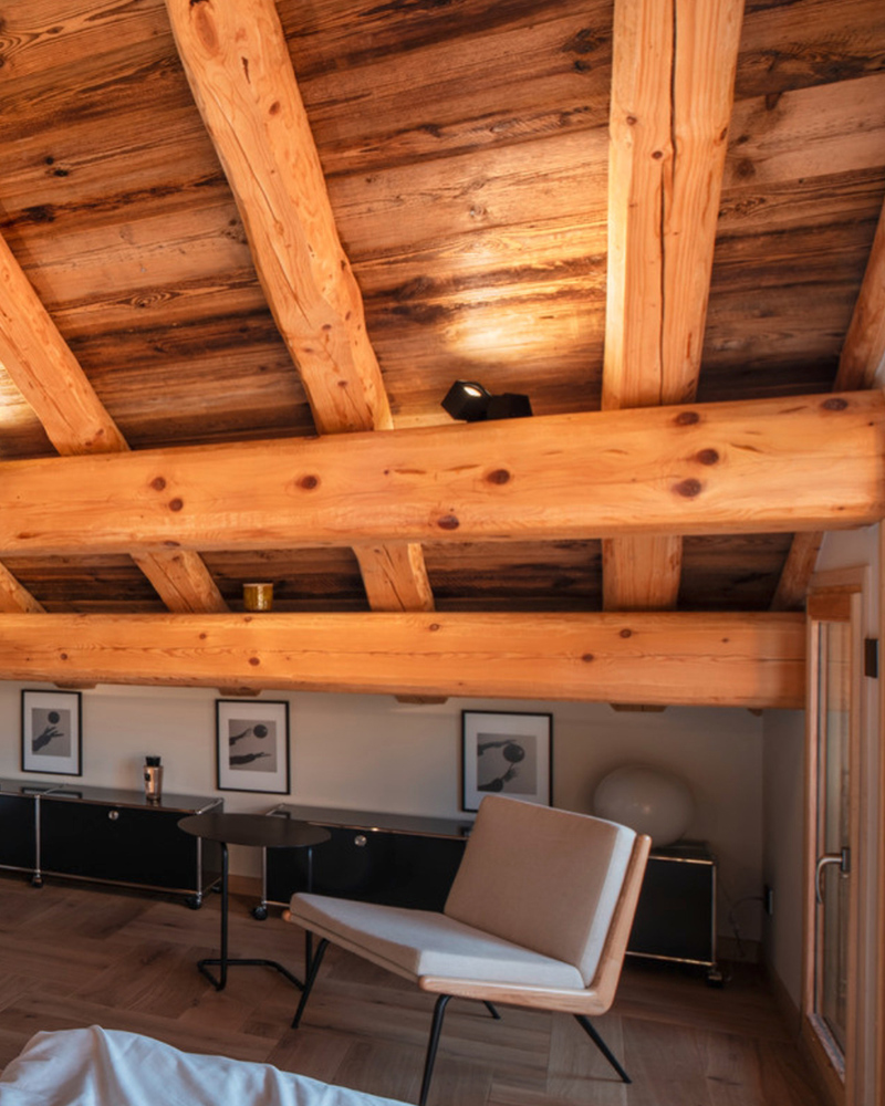 Holzdecke mit Balken und modernen schwarzen LED-Strahlern in einem minimalistisch eingerichteten Wohnraum Holzdecke mit Balken und modernen schwarzen LED-Strahlern in einem minimalistisch eingerichteten Wohnraum