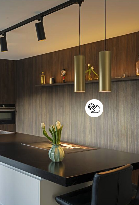 Moderne Deckenlampe in Gold mit nach unten gerichtetem Zylinder über der Arbeitsfläche in der Küche