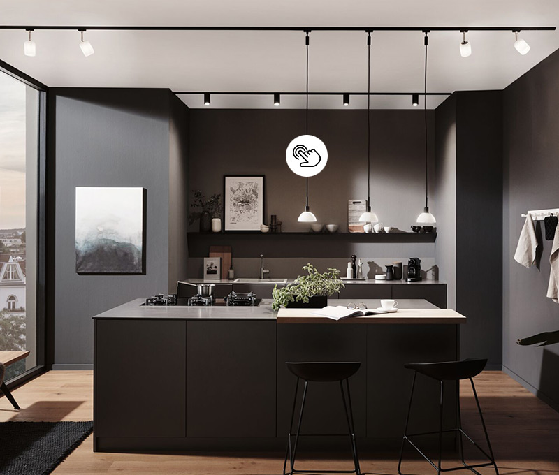 Pendelleuchten mit Glaslampenschirm über moderner Kücheninsel in anthrazit