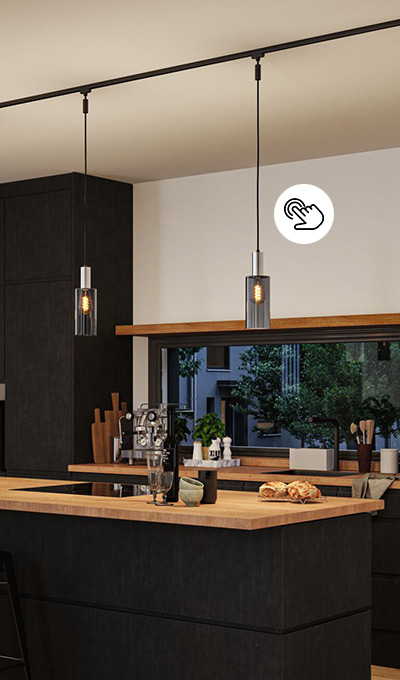 Moderne Pendelleuchte mit Rauchglas Lampenschirm an Schienensystem über der Kochinsel