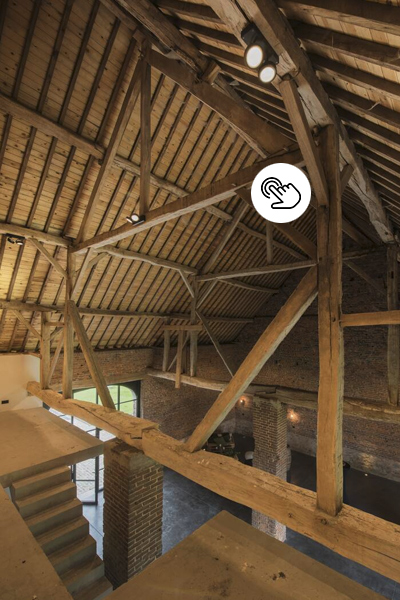 Rustikaler Sichtdachstuhl mit kraftvollen Deckenspots an den Holzbalken