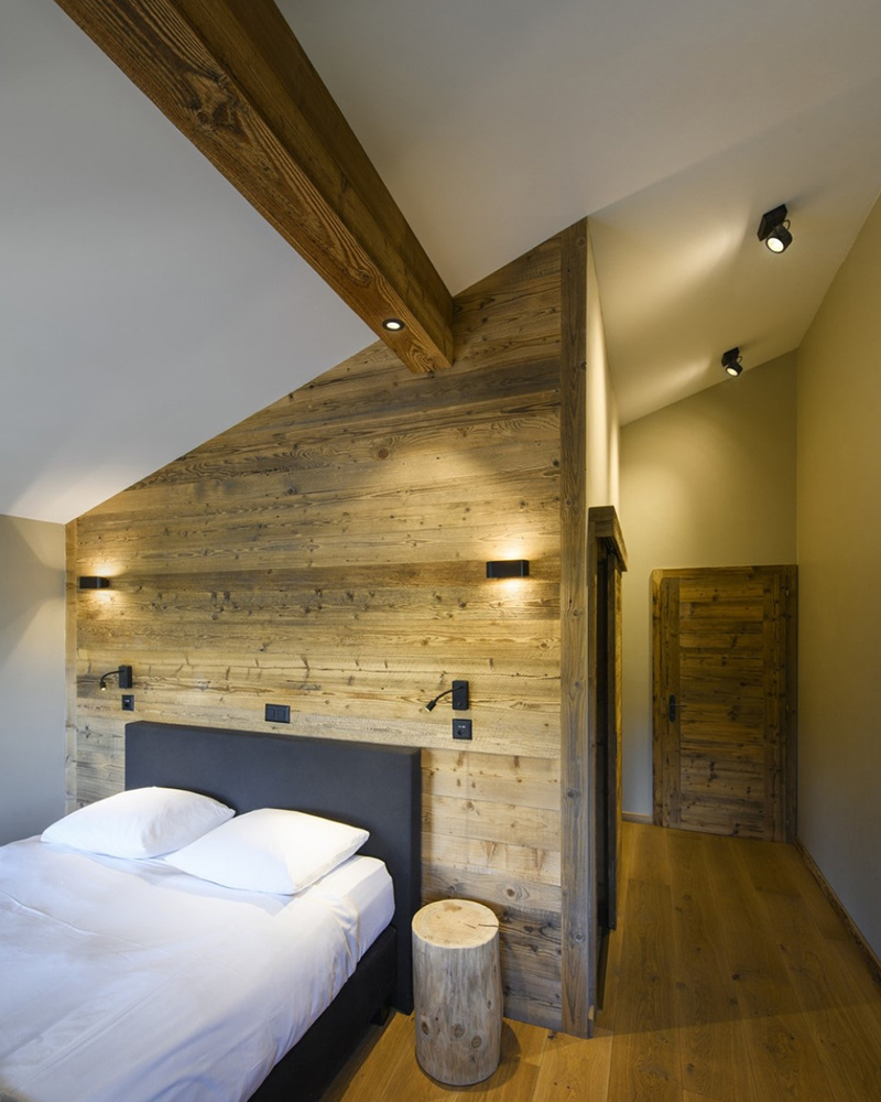 Schlafzimmer mit Dachschräge, beleuchteter Holzwand und Holzbalken samt LED-Einbaustrahlern Schlafzimmer mit Dachschräge, beleuchteter Holzwand und Holzbalken samt LED-Einbaustrahlern
