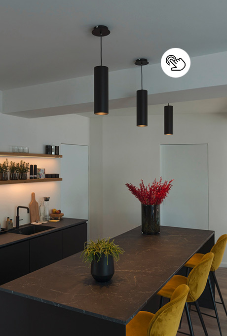 Schwarze zylindrische Downlight-Lampen über einer modernen Kücheninsel